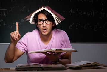 Young male student sitting in classroom