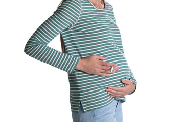 Young pregnant woman smoking cigarette on white background, closeup. Harm to unborn baby