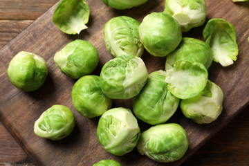 Board with Brussels sprouts on wooden background, top view