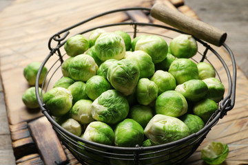 Metal basket with fresh Brussels sprouts on table, closeup