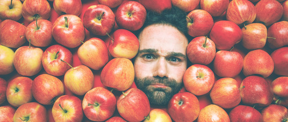 Mann mit Äpfeln , Konzept für Lebensmittelindustrie. Gesicht von lachenden mann  in Apfel Fläche.