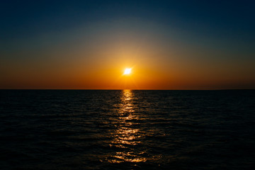 Sunset on the sea or ocean with beautiful blue sky. Sunset or sunrise scene landscape background concept image.