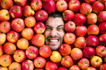 Mann mit Äpfeln , Konzept für Lebensmittelindustrie. Gesicht von lachenden mann  in Apfel Fläche.