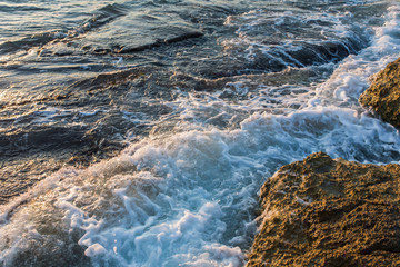 Waves crashing and hitting on the rocks at the ocean or sea. Beautiful scenic nature landscape.