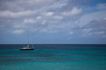 Fototapeta na wymiar Sailboat cruising by the beach in Aruba