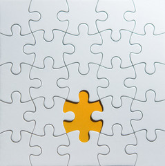 Unfinished white puzzle pieces on orange background