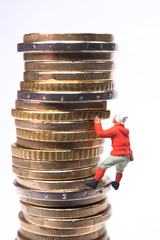 Miniature climber climbing on the stack of coins