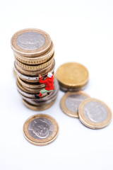 Miniature climber climbing on the stack of coins