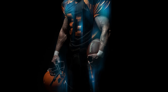 American football player on a dark background in black and orange equipment.