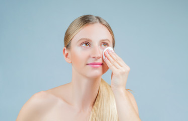 Beautiful woman removing makeup from her face