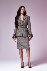 Beautiful woman lady spring autumn collection glamor model business office fashion clothes wear casual style grey color suit blouse jacket skirt office pretty face dark hair background studio.