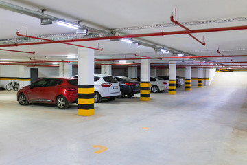 Underground parking garage with various cars. 