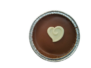 Chocolate cake in a foil cup and white chocolate heart shape on top isolated on white background with clipping path.