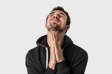 Young caucasian man praying. Isolated on white background.