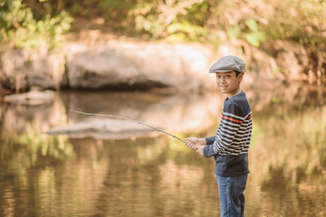 Little Asian boy fishing at the river vintage  retro