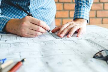 Architect or engineer working in office on blueprint. Architects workplace