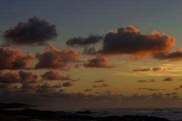 Beautiful sunset on the beach. sun dyes the clouds in golden colors.