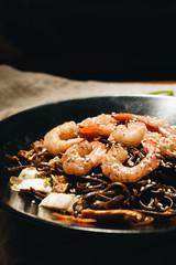 Delicious meal with shrimps in black plate, traditional asian  food 