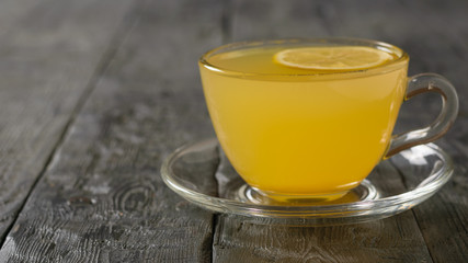 Drink ginger root, lemon, orange, honey and cinnamon on a dark wooden table.