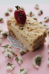 Piece of delicious fresh cake and floral petals 