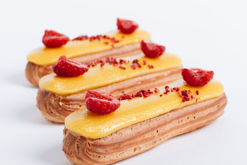 Delicious eclairs with yellow glaze, sweet dessert