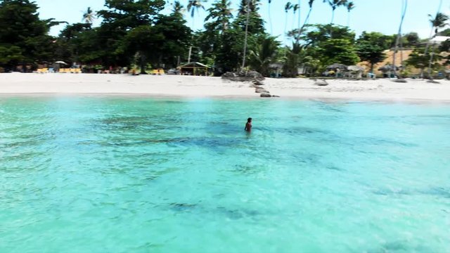 Aerial: Beautiful Woman Walking in the Ocean by Stunning Tropical Beach