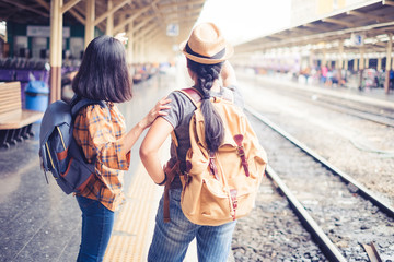 Two people Asian woman tourist standing carrying a backpack. Wait for the train at Hua Lamphong Bangkok Thailand. During his travels in vacation.