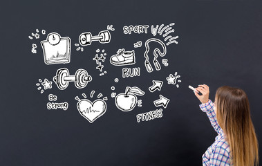 Fitness and diet with young woman writing on a blackboard