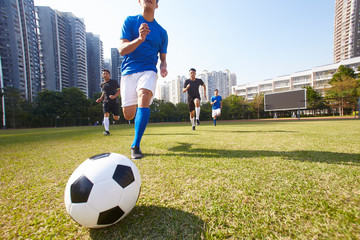 asian soccer football players chasing the ball
