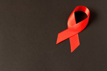 Red aids ribbon.  Isolated on black background with empty space for text.