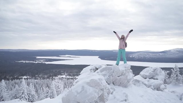 Attractive woman standing and smiling on the top of stones