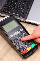 Hand of woman using payment terminal, enter personal identification number