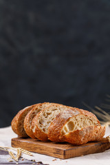 Sliced homemade rye bread on a board close-up on a dark background. The concept of healthy food and traditional bakery.