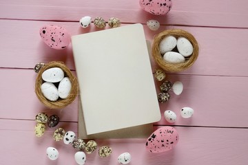 Easter Flat lay.  nest with eggs, blank notepad on a pink pastel wooden board background.Easter holiday.top view, copy space.