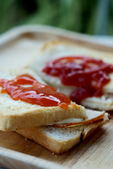 Ham cheese sandwich and tomato ketchup and chili sauce on wood tray and space for write wording, easy delicious food served with coffee or tea in coffee shop or office, popular food for office worker