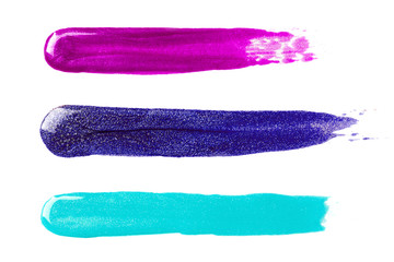 Sparkling nail polish strokes blue, turquoise and purple color isolated on white.