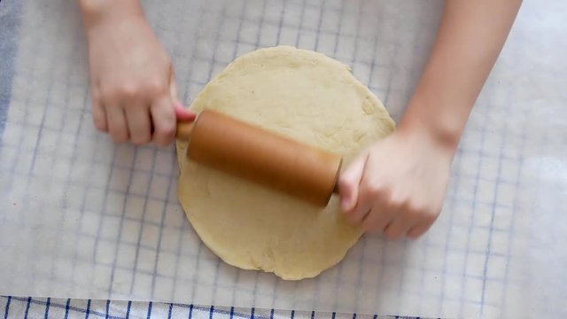 Making pizza or pide dough by close up girl hands in pastry kitchen, shaping dough is precursor to making a wide variety of food stuffs, particularly breads, biscuits, cakes, cookies, dumplings, pasta