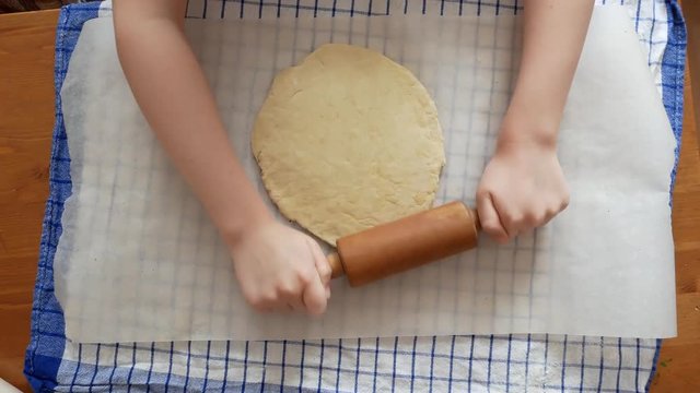 Making pizza or pide dough by close up girl hands in pastry kitchen, shaping dough is precursor to making a wide variety of food stuffs, particularly breads, biscuits, cakes, cookies, dumplings, pasta