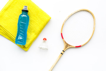 Badminton training concept. Badminton racket, shuttlecock, sport drink and towel on white background top view