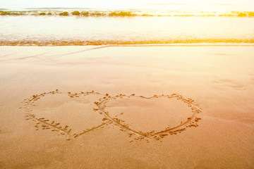 love by Hand write heart on sand at the beach in valentines day