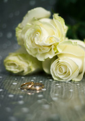 wedding rings on a bouquet of white roses