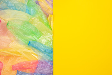 Multicolored single use plastic shopping bags with blank yellow background for text or image