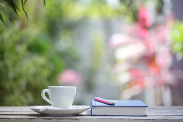 White coffee cup with plant and notebook