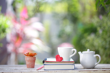 White kettle and cup with red heart and notebooks