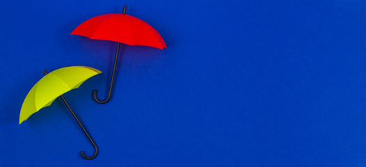 Small colorful umbrellas on blue color background