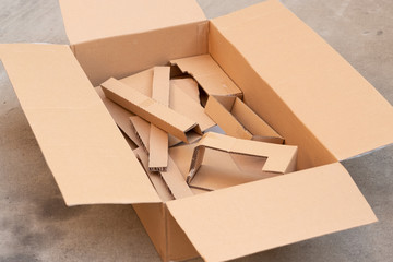 Mixed of small cardboard parts in a big cardboard box