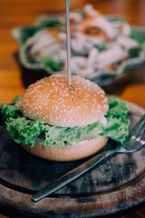 The burgers are on the appetizing wooden plate.