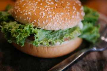 The burgers are on the appetizing wooden plate.
