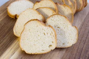 Slices of baguette on a wooden plate. Bread plate. Close-up.