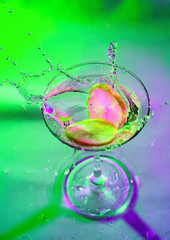 colorful cocktail in glass with splashes and lemon